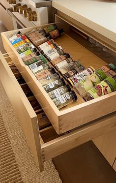 an open drawer in a kitchen filled with spices