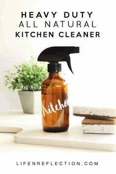 a bottle of kitchen cleaner sitting on top of a counter next to some cookies and a potted plant