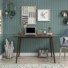 a laptop computer sitting on top of a wooden desk in front of a green wall