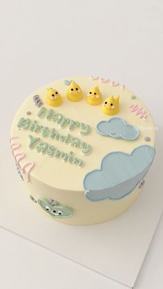 a birthday cake decorated with rubber ducks and clouds