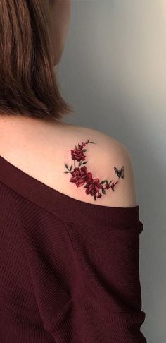 a woman's shoulder with red flowers on it