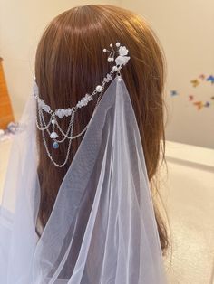 the veil is adorned with jewels and pearls