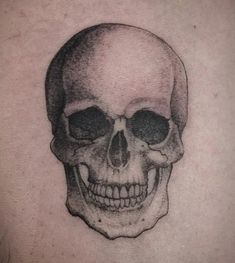 a black and white skull tattoo on the chest