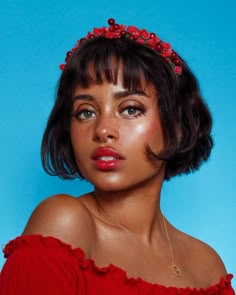 a woman wearing a red dress with a flower crown on her head, against a blue background