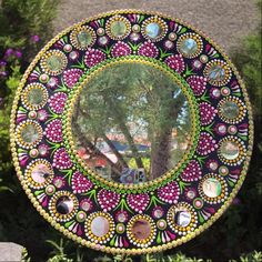 a decorative mirror sitting on the side of a tree