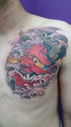 a man with a tattoo on his chest has a dragon head and clouds in the background