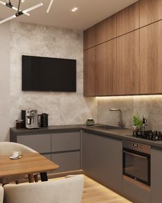 a kitchen with wooden cabinets and grey counter tops, white chairs and a television mounted on the wall