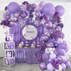 a purple and white baby shower with balloons