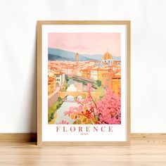 a framed print of the city of florence, italy with flowers in front of it