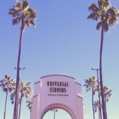 the entrance to universal studios is surrounded by palm trees