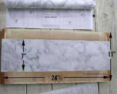 the measurements for marble paper are shown on top of wood planks and next to a ruler