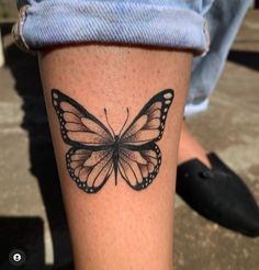 a black and white butterfly tattoo on the leg