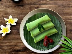 some food is sitting on a plate next to flowers and a cup with tea in it