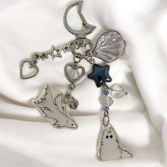 a key chain with charms attached to it on a white fabric background in close up