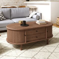 a living room with a couch, coffee table and rug on the floor in front of it