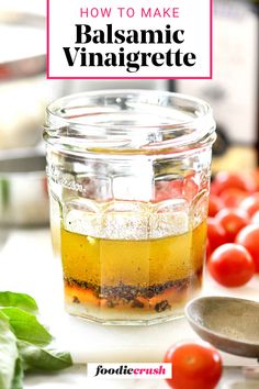 a jar filled with balsamic vinaigrete next to tomatoes and basil