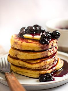 a stack of pancakes with blueberries and syrup