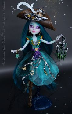 a doll with blue hair wearing a green dress and hat, holding a skeleton key