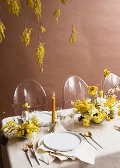 the table is set with yellow flowers and silverware