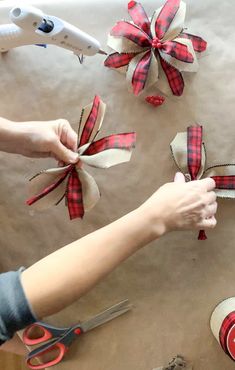 someone is cutting ribbon with scissors and other items on the table next to them that are wrapped in burlap