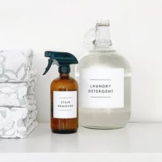 a bottle of laundry deterant next to a stack of towels on a white surface