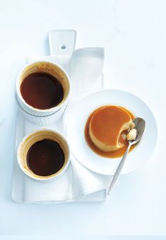 two cups of coffee on a plate with spoons