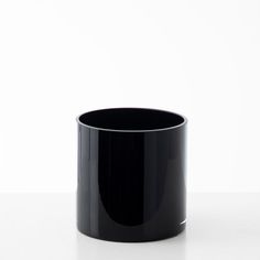 a black cup sitting on top of a white table