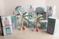 several cardboard boxes with palm trees and buildings on them, all made out of paper