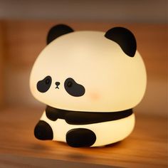 a panda bear lamp sitting on top of a wooden table