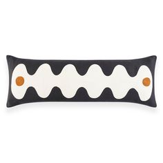 a black and white pillow with orange dots