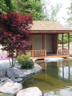 a gazebo in the middle of a pond surrounded by rocks