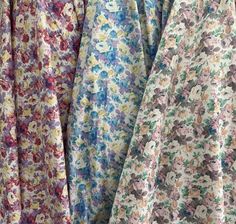 three different colored dresses hanging on a rack