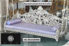 an ornate silver bench with purple cushions in a room filled with wooden shelves and other items