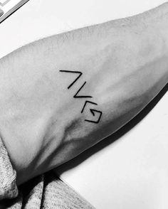 a black and white photo of a person's arm with the word love tattooed on it