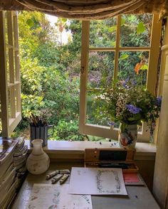 an open window in a room filled with lots of plants and papers on top of a desk