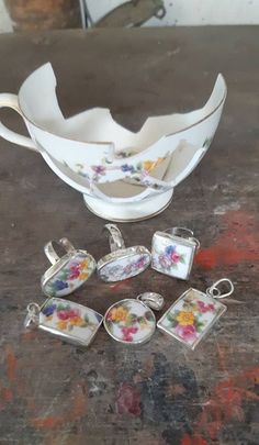 a bowl and five pieces of jewelry sitting on a table