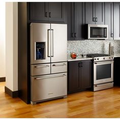 a modern kitchen with stainless steel appliances and wood flooring is pictured in this image