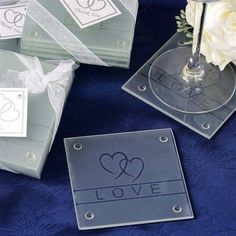 clear acrylic coasters with love written on them and white flowers in the background