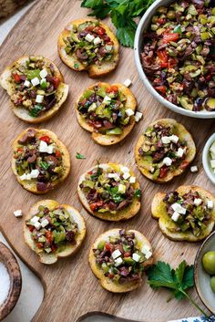 an assortment of appetizers with olives and feta cheese on a cutting board