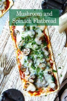 mushroom and spinach flatbread on a cutting board with pizza cutters next to it