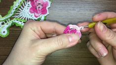 someone is crocheting flowers on a piece of yarn