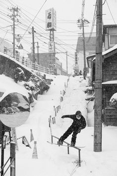 a man riding a snowboard down the side of a rail