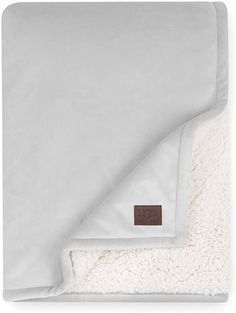 the white blanket is folded up and laying on it's side, with a brown patch