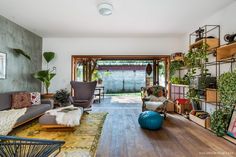 a living room filled with furniture and lots of plants