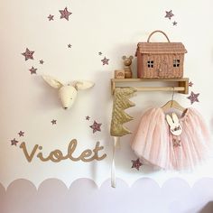 the wall is decorated with pink and gold decorations, including a wooden sign that says violet