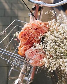 a basket filled with lots of flowers sitting on top of a sidewalk