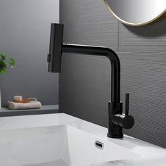 a bathroom sink with a black faucet and mirror