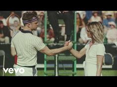 two tennis players shaking hands in front of an audience