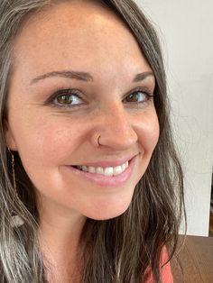 a close up of a person smiling with food in front of her and the background