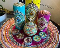 there are many colorful vases on the table and one is made out of beads